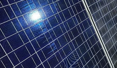 Nahaufnahme zweier blauer Solarzellenpaneele mit reflektierendem Licht.